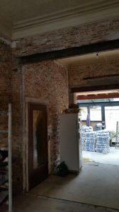 Slecht gemetste muren in oud metselwerk tijdens een renovatie waar momenteel de bruine kalkmortelbezetting is afgekapt.